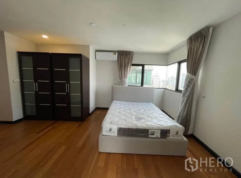 Condominium for rent - Corner bedroom with twin wardrobes, air conditioner and city views.
