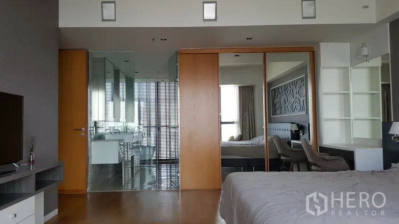 คอนโด ให้เช่าในSathon, Bangkok - ห้องนอนใหญ่กว้าง ประตูบานเลื่อนสีไม้สู่ห้องน้ำกระจก ตู้เสื้อผ้าบานกระจก และพื้นไม้