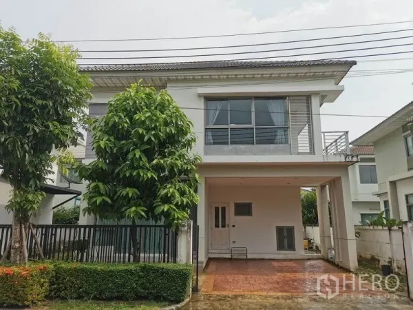 独立式住宅 出租在Prawet, Bangkok - 两层独栋别墅外观，带有覆盖车位、围栏与小花园。