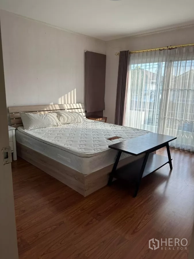 Detached House for rent or sale in Bang Phli, Samut Prakan - Primary bedroom with wood flooring, large windows and access to the balcony.