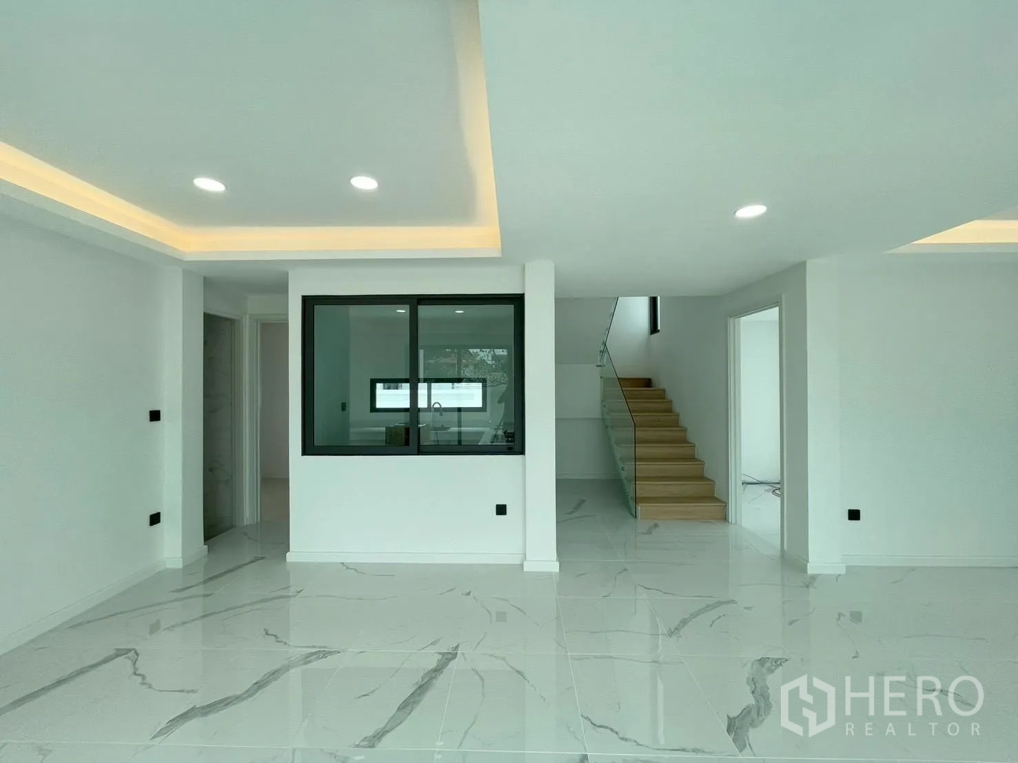 บ้านเดี่ยว for sale in Chatuchak, Bangkok - พื้นที่นั่งเล่นชั้นล่างปูกระเบื้องลายหินอ่อน มองเห็นครัว