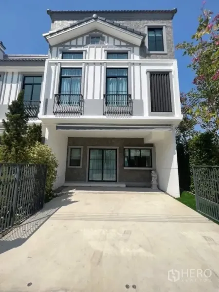 Townhouse for rent in Bang Phli, Samut Prakan - Townhouse exterior with an elegant facade, gated driveway, and covered carport.