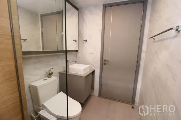 公寓 出租或出售在Watthana, Bangkok - 第二卫浴，镜柜、方形台盆与中性色墙砖。