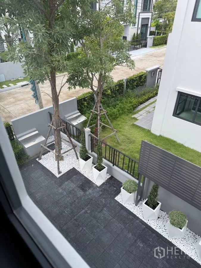 Detached House for rent in Bang Phli, Samut Prakan - View from the upper floor over the paved courtyard with planter boxes and trees.