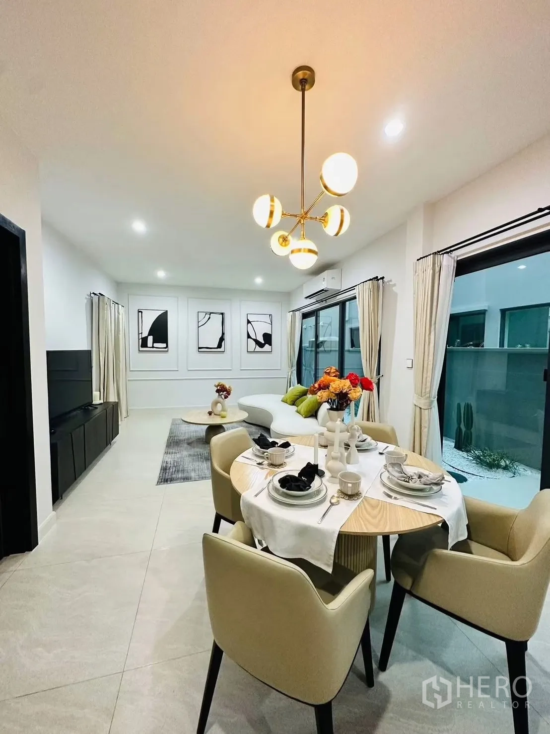 联排别墅 for rent in Suan Luang, Bangkok - 餐区四人餐桌，现代吊灯，旁为推拉玻璃门。