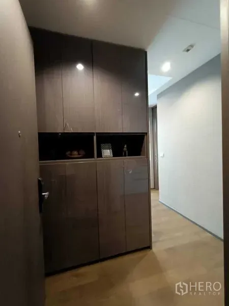 Condominium for rent or sale in Bang Rak, Bangkok - Entry foyer with floor-to-ceiling glossy cabinets and wood flooring in a modern condo.