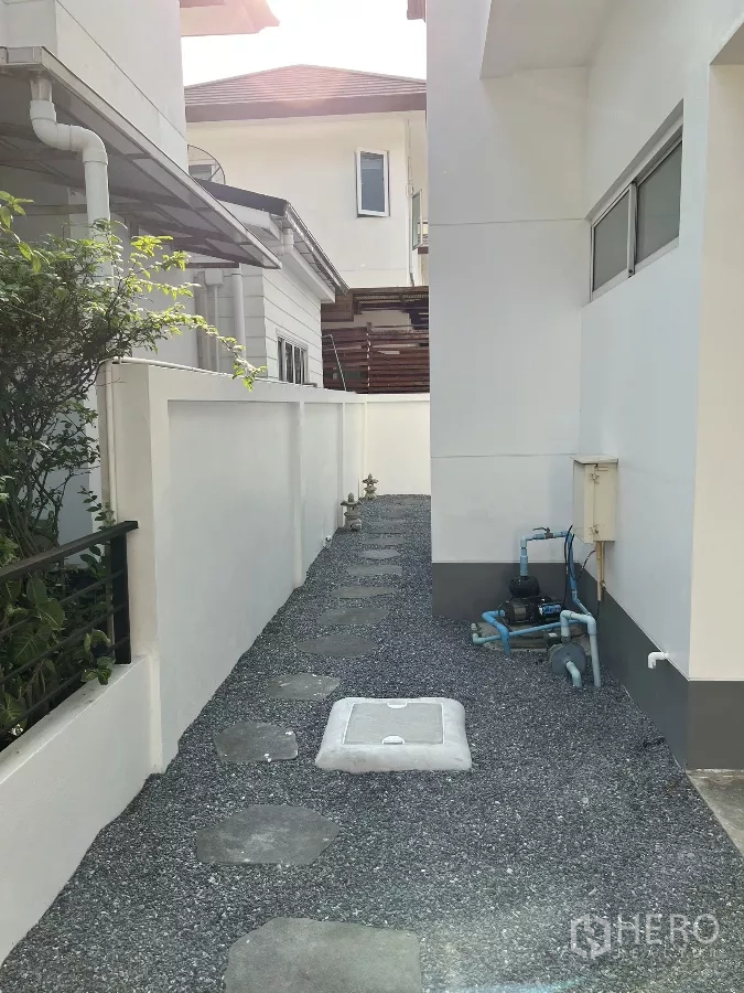 独立式住宅 出租或出售在Saphan Sung, Bangkok - 房屋侧面服务通道，碎石路、仪表与水泵。