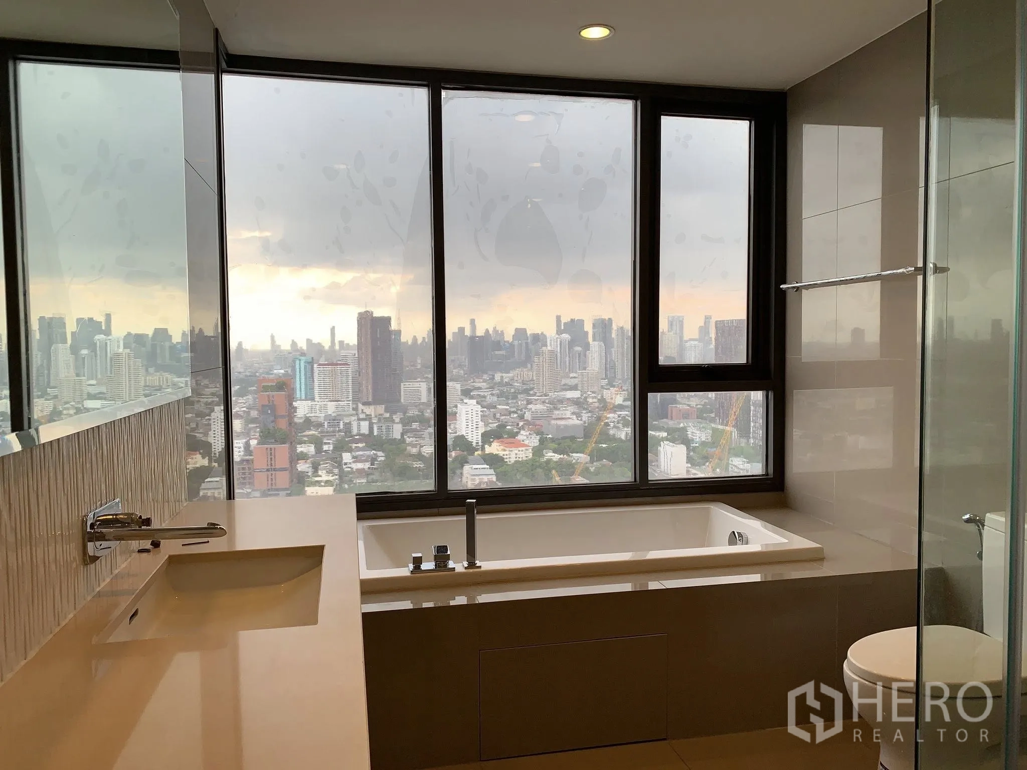 คอนโด for rent in Khlong Toei, Bangkok - ห้องน้ำมีหน้าต่างบานใหญ่ อ่างอาบน้ำ และวิวสกายไลน์ของเมือง