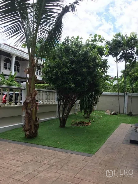 独立式住宅 出租在Khlong Toei, Bangkok - 私家庭院草坪修剪整齐，配棕榈与铺装步道。