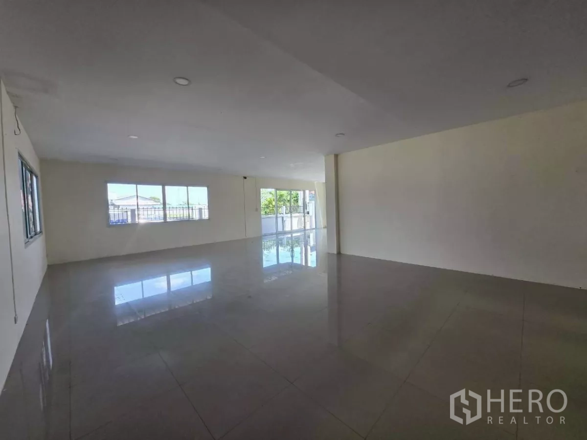 Factory for rent or sale in Mueang Samut Sakhon, Samut Sakhon - Rear service area along the warehouse exterior with a small utility shed and drainage behind the boundary wall.