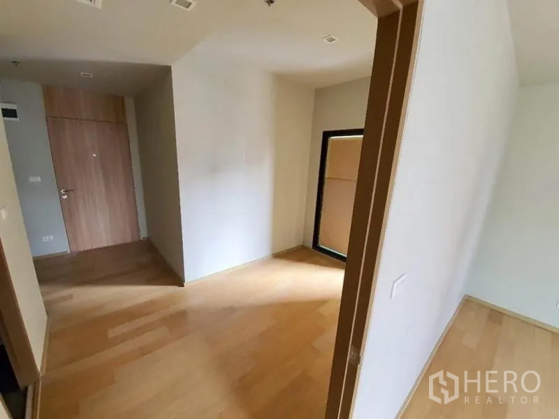 公寓 出售在Ratchathewi, Bangkok - 靠近入户门的起居角落，设窗户、素雅墙面与木地板。