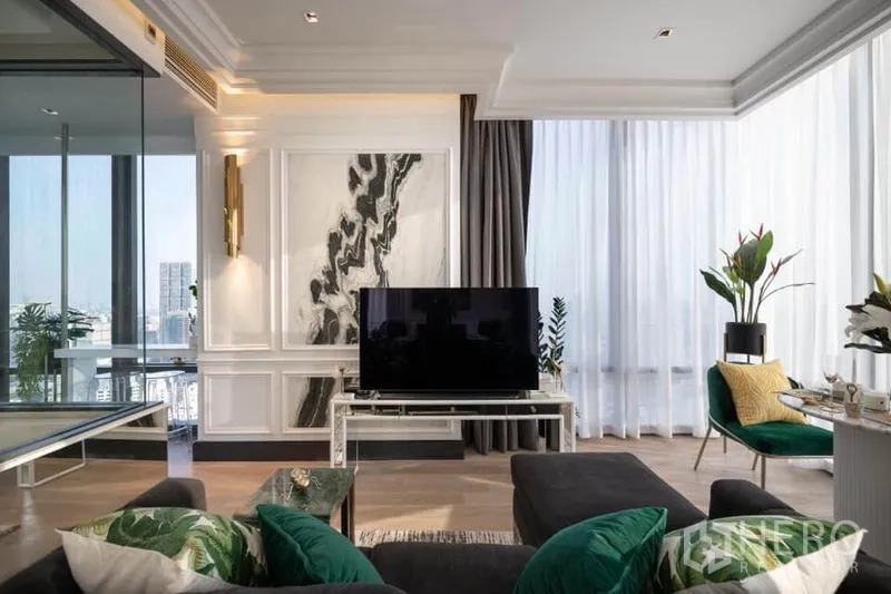 公寓 出租在Bang Rak, Bangkok - 客厅带大理石特色墙与大屏电视，旁有绿植与环幕落地窗