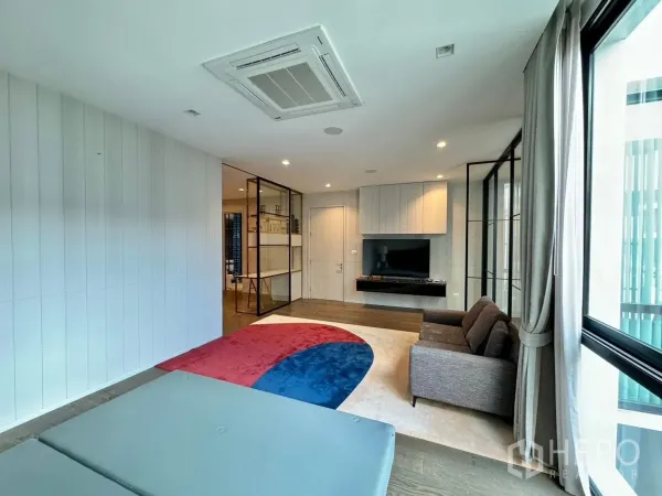 独立式住宅 出租或出售在Prawet, Bangkok - 明亮的起居睡眠区，电视背景墙、沙发与彩色地毯。