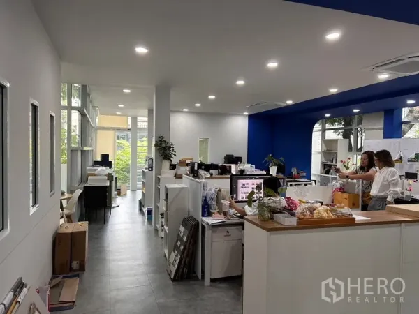 办公空间 出租在Khlong Toei, Bangkok - 明亮开放办公区，嵌入式照明，白色工位与蓝色点缀墙，侧面大窗引光入内。