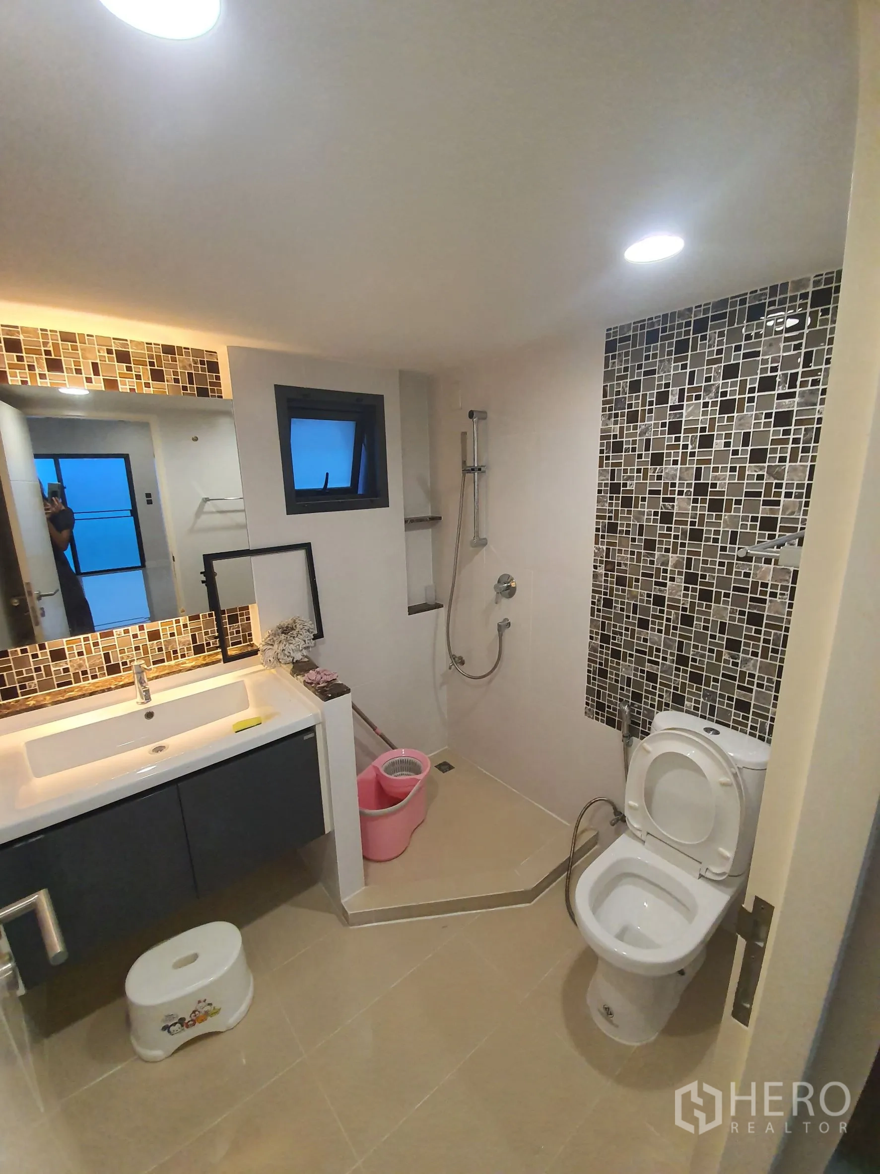 Detached House for rent in Bang Kapi, Bangkok - Ground-floor bathroom with mosaic accent wall, vanity and walk-in shower.