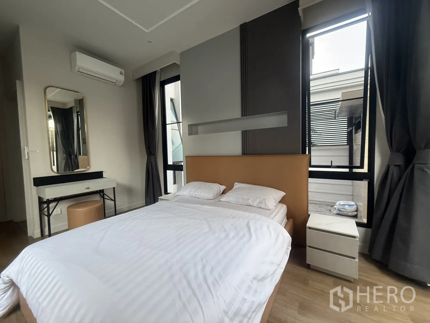 Detached House for rent in Saphan Sung, Bangkok - Bedroom with makeup vanity, side tables and twin windows.