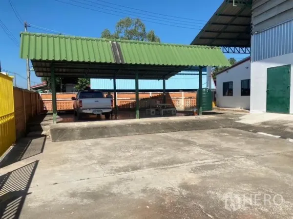 货栈 出租在Mueang Rayong, Rayong - 院内带绿色顶棚的装卸与停车区，混凝土地面。