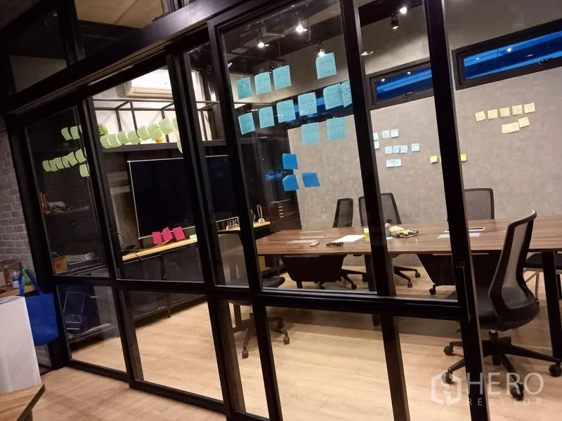 Office Space for rent in Chatuchak, Bangkok - Glass-walled meeting room with large conference table, TV and sticky notes on the glass.