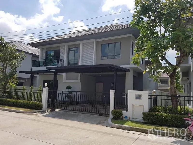 Detached House for rent or sale in Saphan Sung, Bangkok - Modern two-storey detached house with gated carport and landscaped front yard.