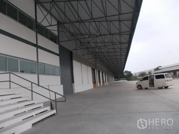 Warehouse for rent in Si Racha, Chon Buri - Wide canopy truck court with roller doors, steps and ample turning space beside the warehouse.