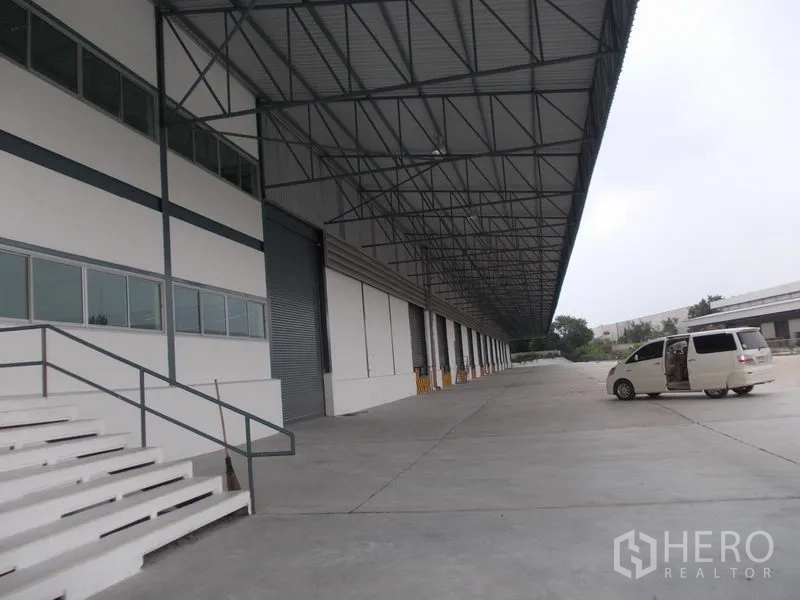 Warehouse for rent in Si Racha, Chon Buri - Wide canopy truck court with roller doors, steps and ample turning space beside the warehouse.