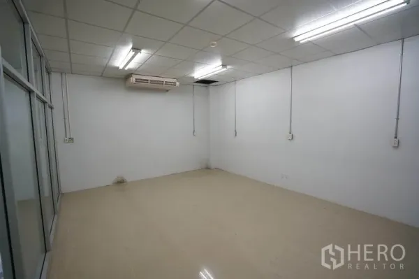 Factory for sale in Khlong Luang, Pathum Thani - Air-conditioned white office room with tiled floor and fluorescent lighting.