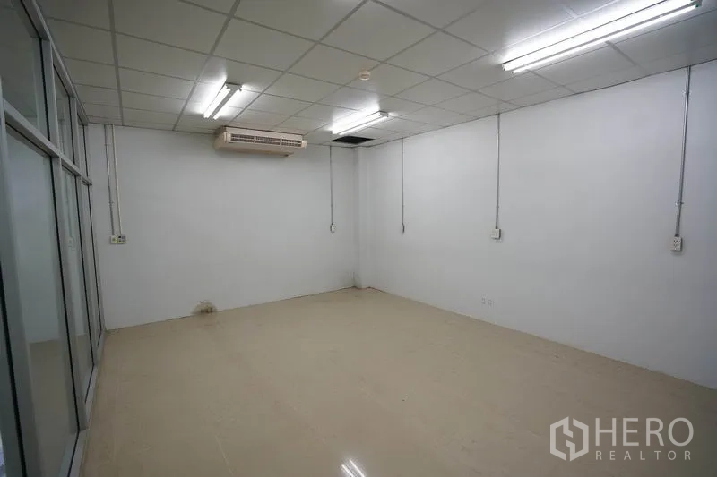 Factory for sale in Khlong Luang, Pathum Thani - Air-conditioned white office room with tiled floor and fluorescent lighting.