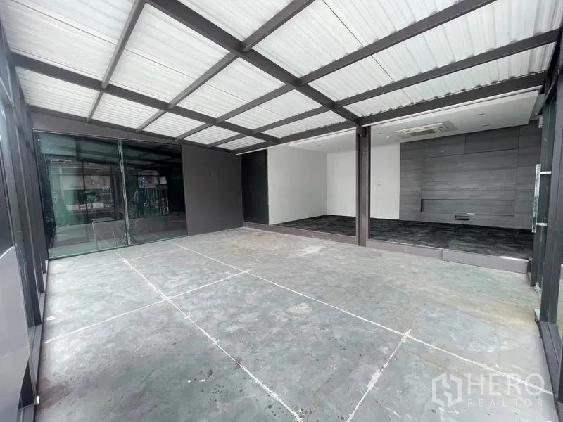 Office Space for rent in Bang Na, Bangkok - Covered entry leading to modern office with sliding glass doors and dark tile flooring.