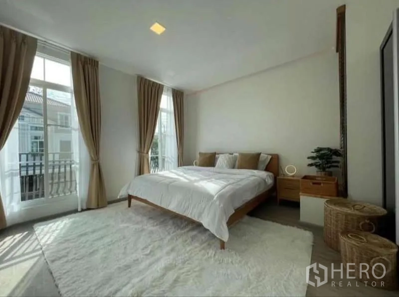 联排别墅 出租在Prawet, Bangkok - 主卧，大面积落地窗与窗帘，浅色地毯