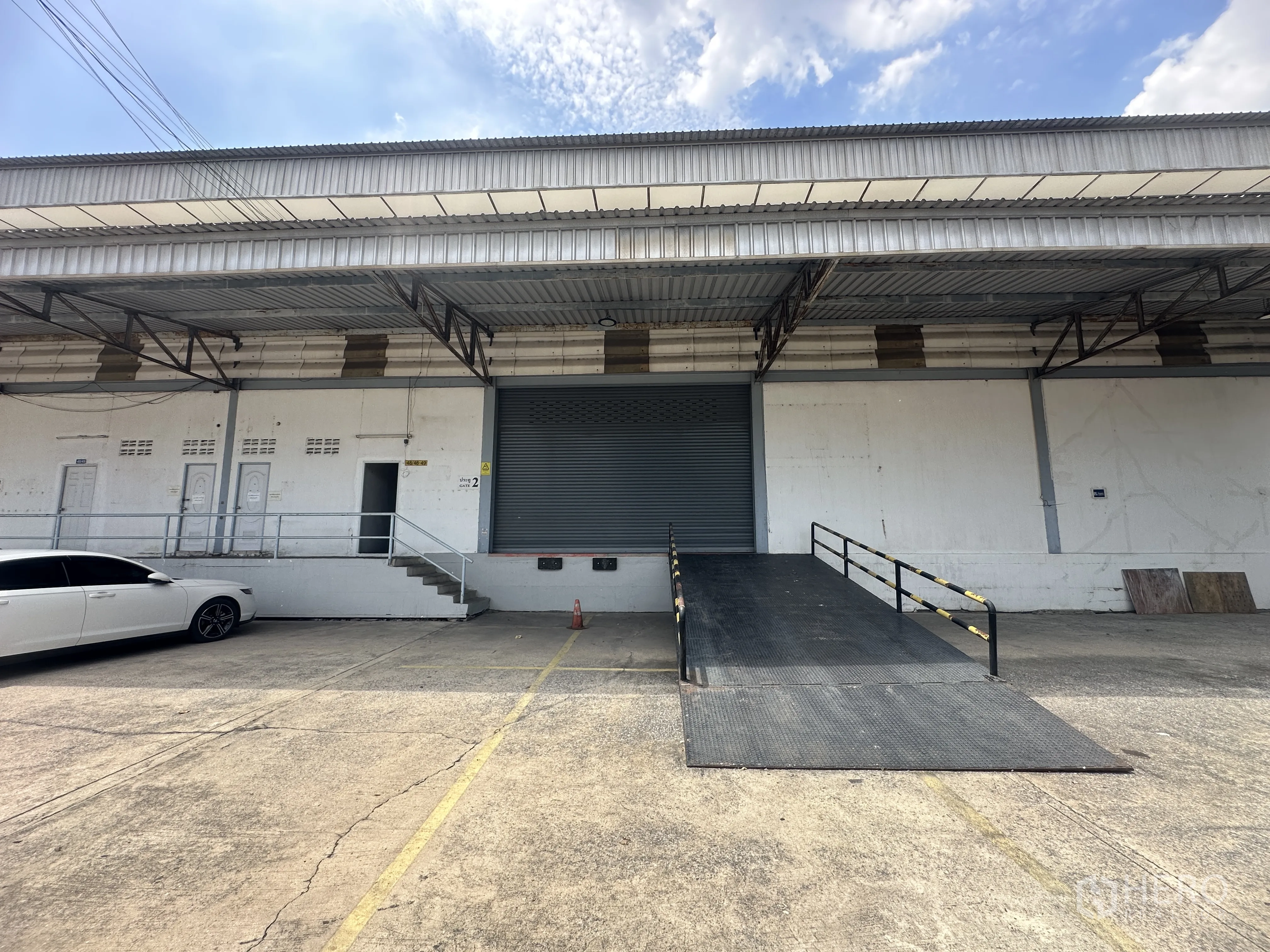 Warehouse for rent in Khlong Luang, Pathum Thani - Close-up of a loading bay with roll-up door and ramp up to the raised platform.