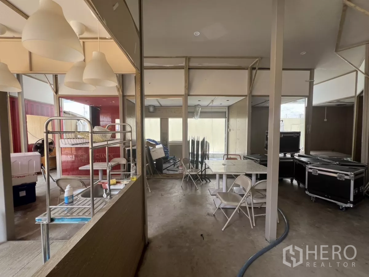 零售空间 出租在Khlong Toei, Bangkok - 宽阔室内配吊灯、备餐水槽、桌子与可移动置物架，半精装布局。