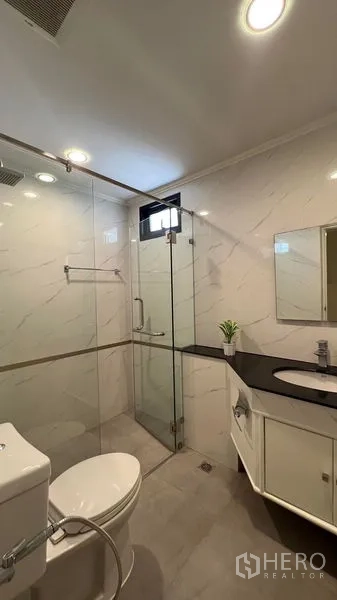 คอนโด ให้เช่าในWatthana, Bangkok - ห้องน้ำสมัยใหม่ ฝักบัวกระจกนิรภัย ฝักบัวเรนชาวเวอร์ ผนังลายหินอ่อน และเคาน์เตอร์สีดำ