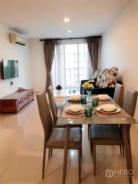 公寓 出租在Phaya Thai, Bangkok - 采光好的客餐厅，四人餐桌、沙发、电视，并有落地推拉门通向阳台。