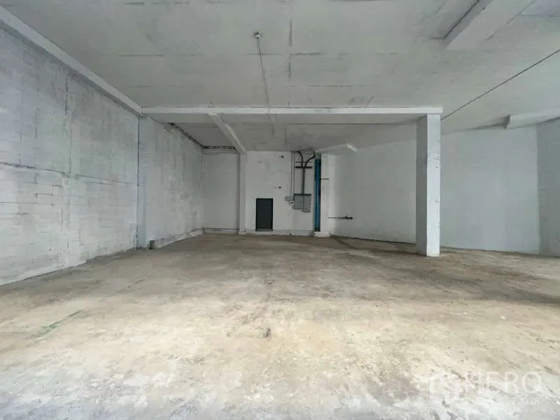 Retail Space for rent in Khlong Toei, Bangkok - Unfurnished retail shell showing tall ceiling and utility points on the back wall.