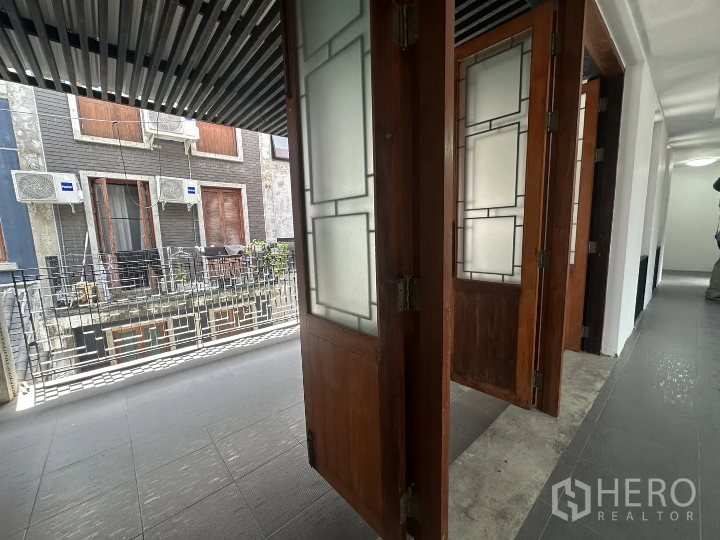 带办公室的家 出租在Pathum Wan, Bangkok - 木质折叠门特写，打开通向阳台，外墙空调机位可见。