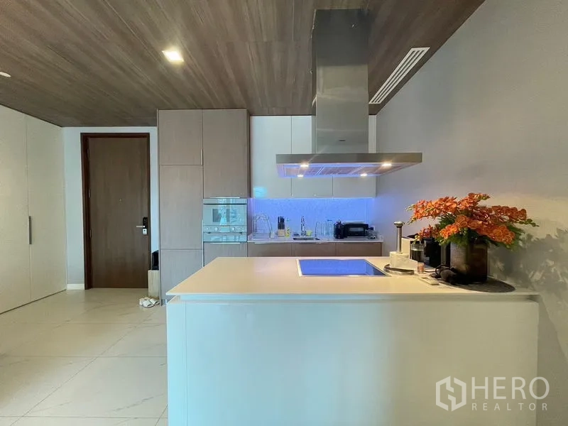 Condominium for rent in Pathum Wan, Bangkok - Close view of kitchen island with blue backsplash lighting and storage.