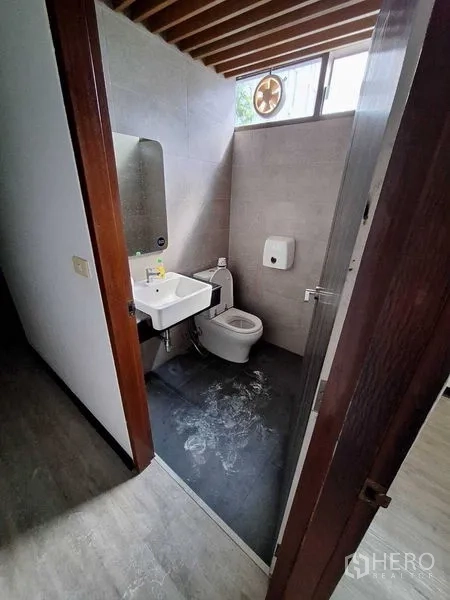 办公空间 出租在Watthana, Bangkok - 现代卫生间，坐便器、洗手盆、排气扇与格栅吊顶。
