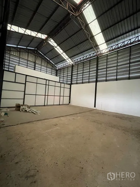 Factory for rent in Lat Lum Kaeo, Pathum Thani - High-bay warehouse section with ventilated metal walls and a white partition.