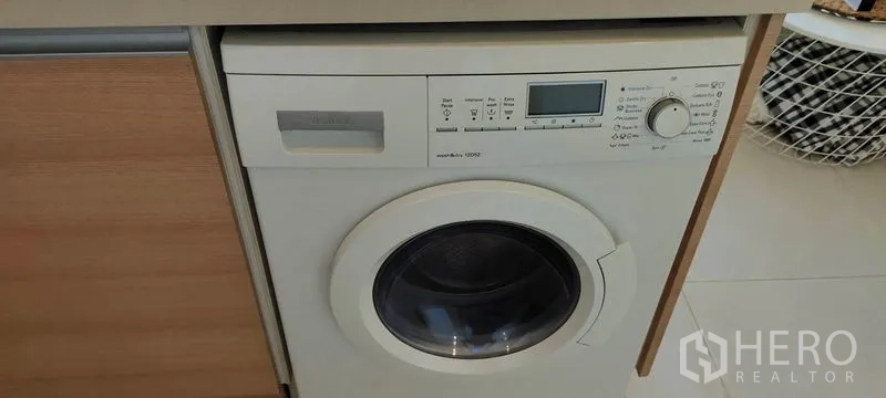 Condominium for rent or sale in Khlong Toei, Bangkok - Front-load washing machine integrated beneath the countertop.