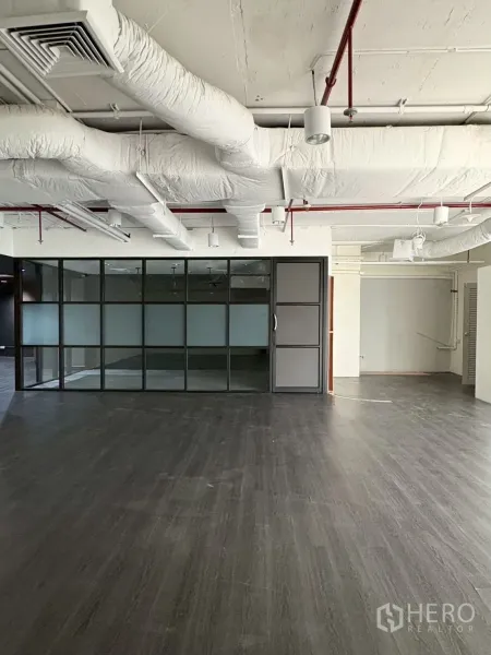 Office Space for rent in Khlong Toei, Bangkok - Open office showing a glass meeting room partition and ducted ceiling.