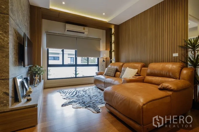 บ้าน ให้เช่าในPhasi Charoen, Bangkok - ห้องดูทีวี โซฟาหนังเข้ามุม ผนังทีวี และผนังไม้โทนอุ่น