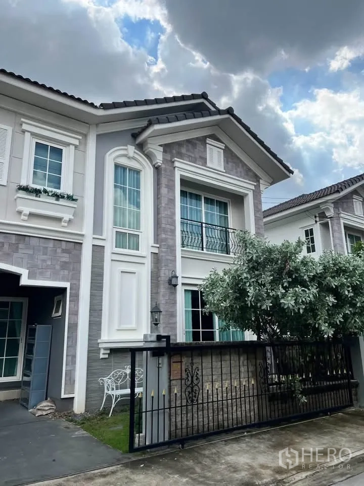 半独立式住宅 for rent in Prawet, Bangkok - 半独立屋外观，石材立面、阳台与小草坪带铁门