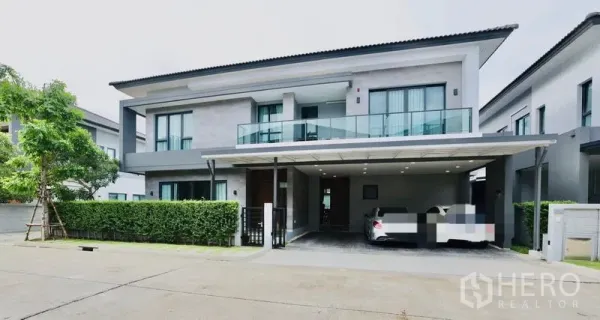 บ้าน ให้เช่าในBang Phli, Samut Prakan - มุมมองด้านหน้าบ้านเดี่ยวสมัยใหม่พร้อมแนวพุ่มไม้และทางรถเข้า
