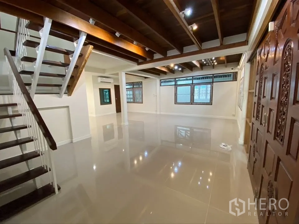 Detached House for rent in Suan Luang, Bangkok - Open living area with staircase and wooden double doors.