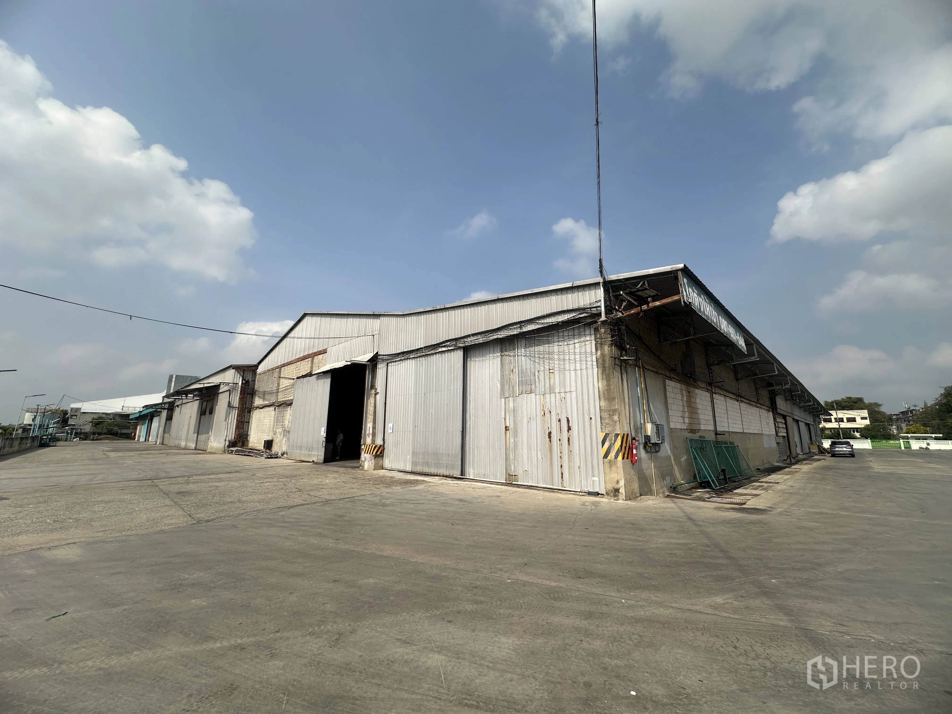 Warehouse for rent in Mueang Pathum Thani, Pathum Thani - Row of connected warehouse bays in metal cladding with ample driveway for container access.