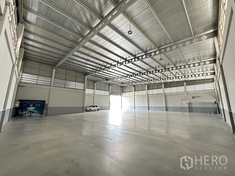 Factory for rent or sale in Lam Luk Ka, Pathum Thani - Bright warehouse hall with wide span, louvered windows and smooth concrete floor.