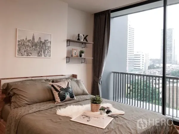 公寓 出租或出售在Bang Rak, Bangkok - 明亮卧室，落地窗与阳台栏杆、置物架与城市景观。