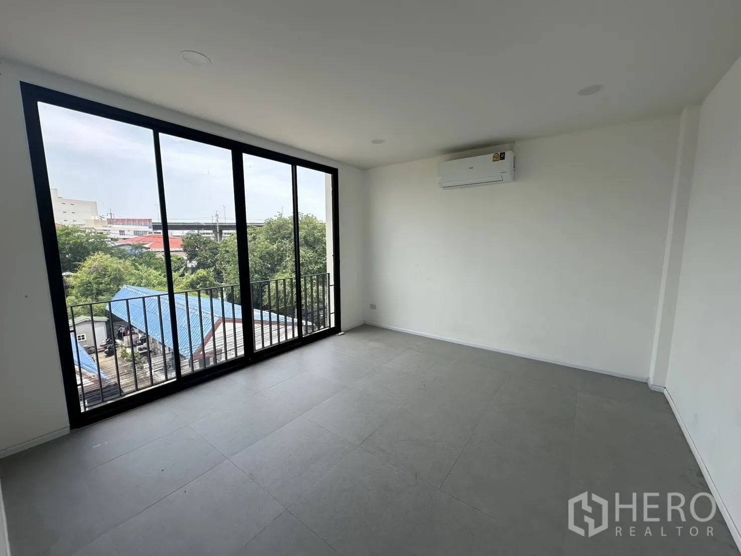Home Office for rent or sale in Bang Na, Bangkok - Corner room with floor-to-ceiling sliding windows and neighborhood view.