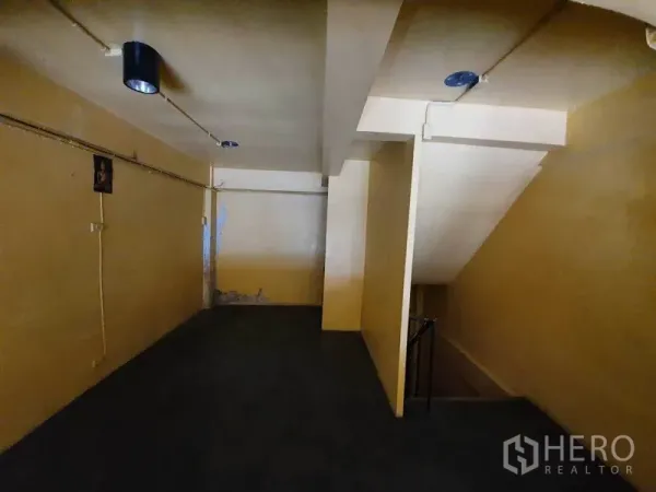 Shophouse for rent in Watthana, Bangkok - Upper level corridor with staircase and ceiling lights in a shophouse.