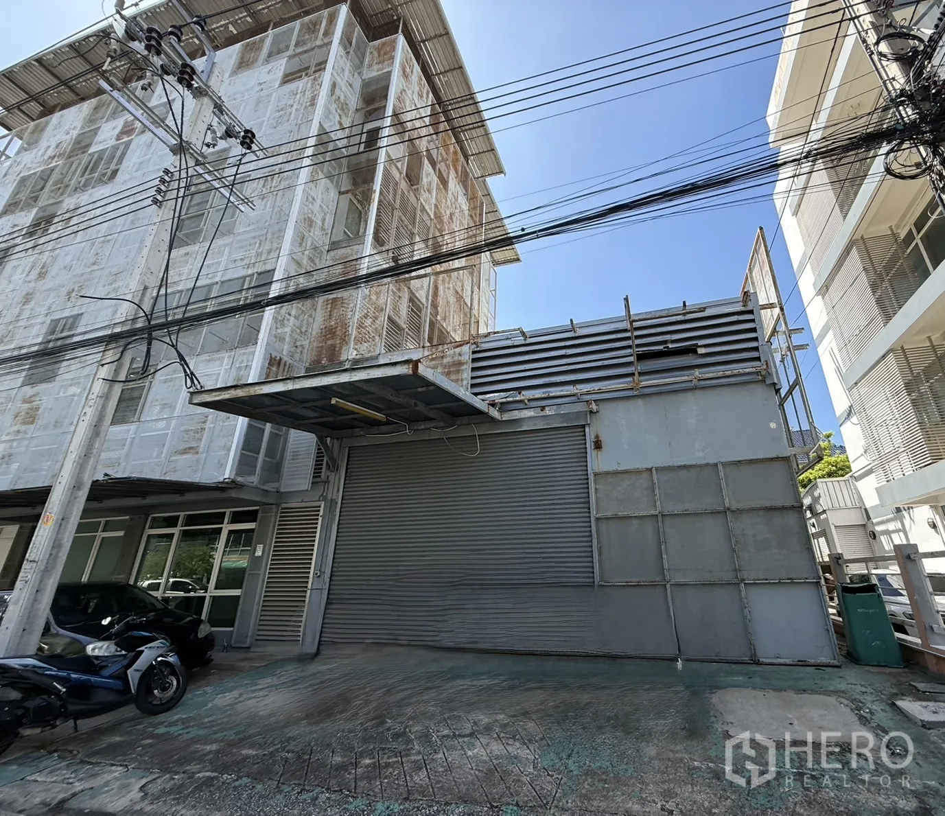 办公空间 出租在Bueng Kum, Bangkok - 办公楼旁的仓库卷闸门与装卸雨棚